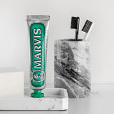 Marvis toothpaste tube on a marble tray with a white background